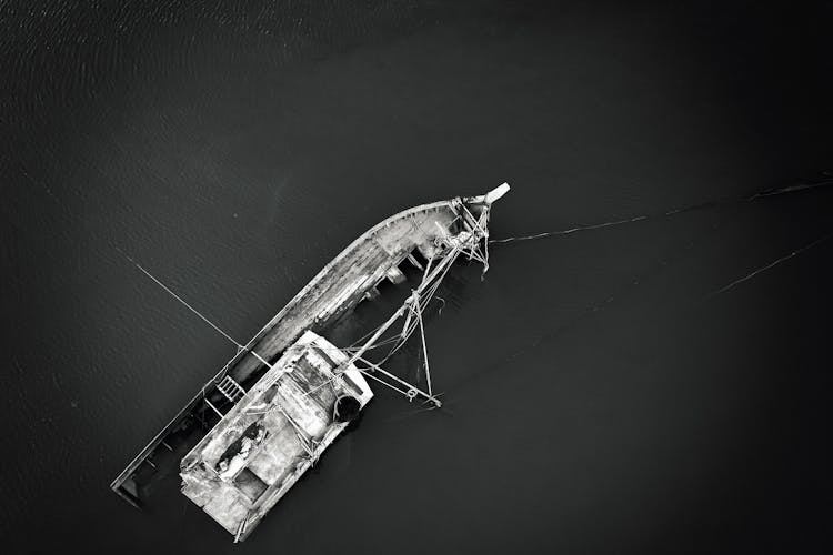 A Grayscale Of A Sinking Boat