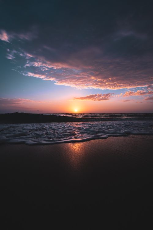 Free Captivating sunset over the Florida coast with waves gently crashing on the shore. Stock Photo