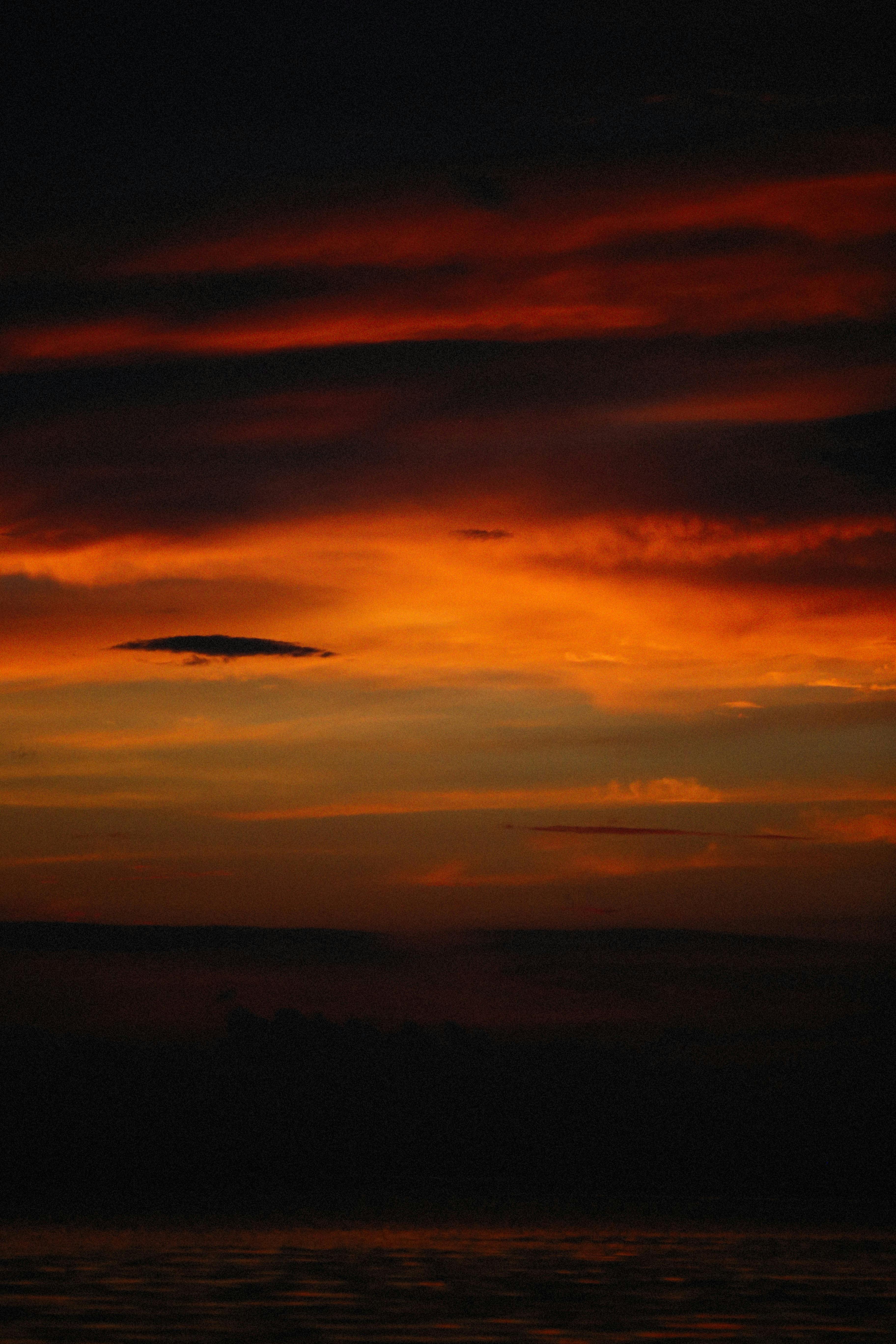 Sensual couple in intimate hold, rain blurred outside window, dark romantic bedroom atmosphere