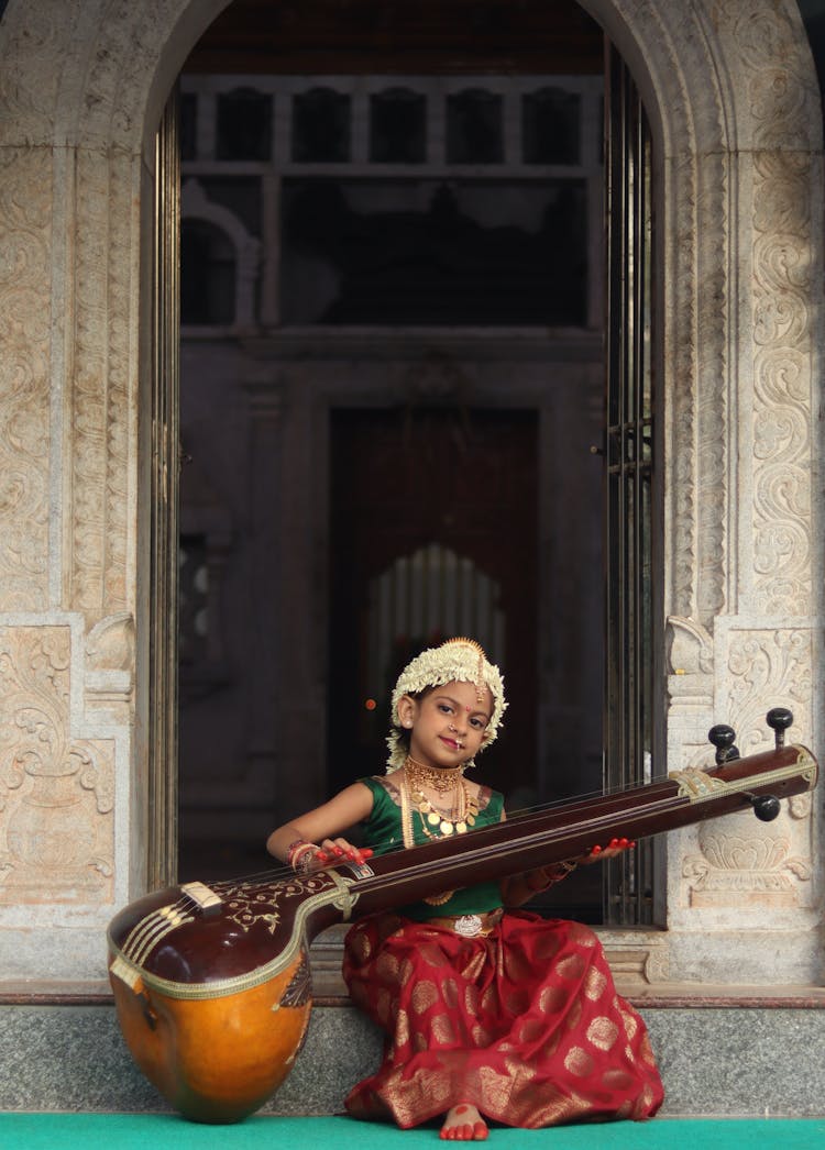 Cute Girl Playing Tanpura Instrument
