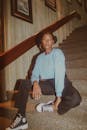 Woman in Leisure Clothes Sitting on Carpeted Stairs at Home