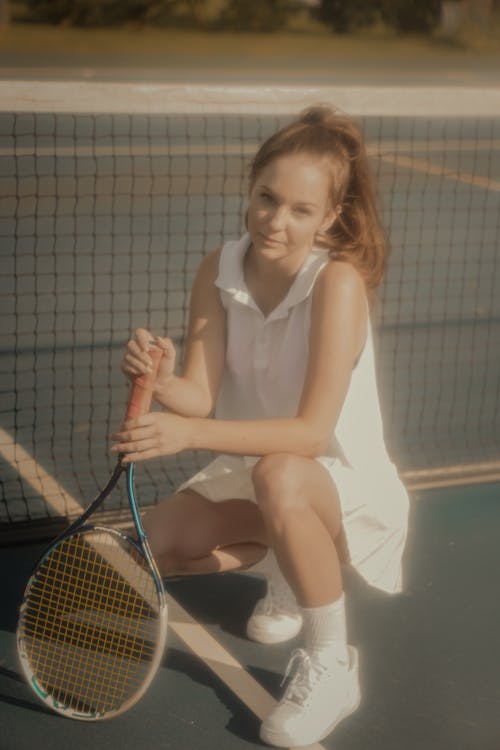 Free A Woman in White Tennis Outfit Holding a Tennis Racket Stock Photo