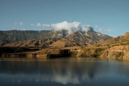Free Peaceful mountain landscape with a serene lake and low clouds at dawn. Stock Photo