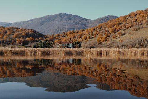 Free Picturesque autumn scenery of Florina, Greece with a serene lake and mountain reflections. Stock Photo