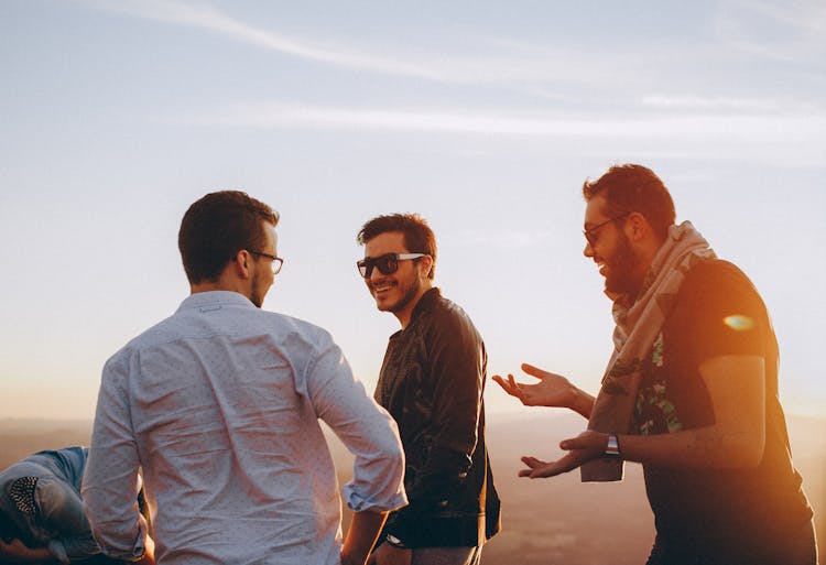 Three Men Standing While Laughing