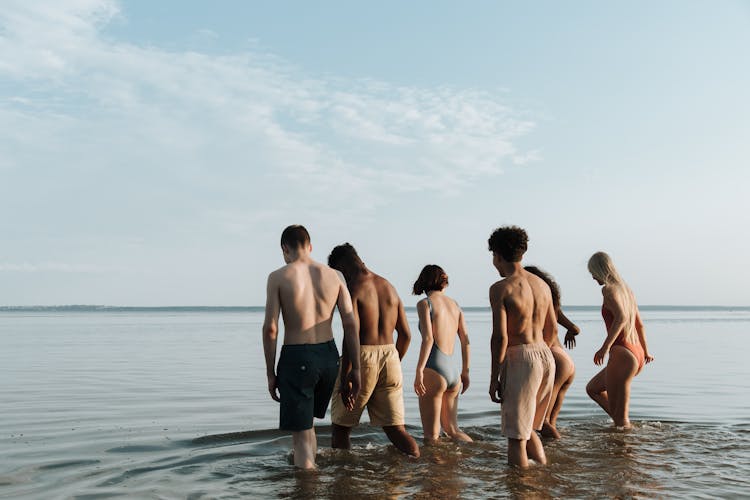 Group Of People Standing On Ocean Water