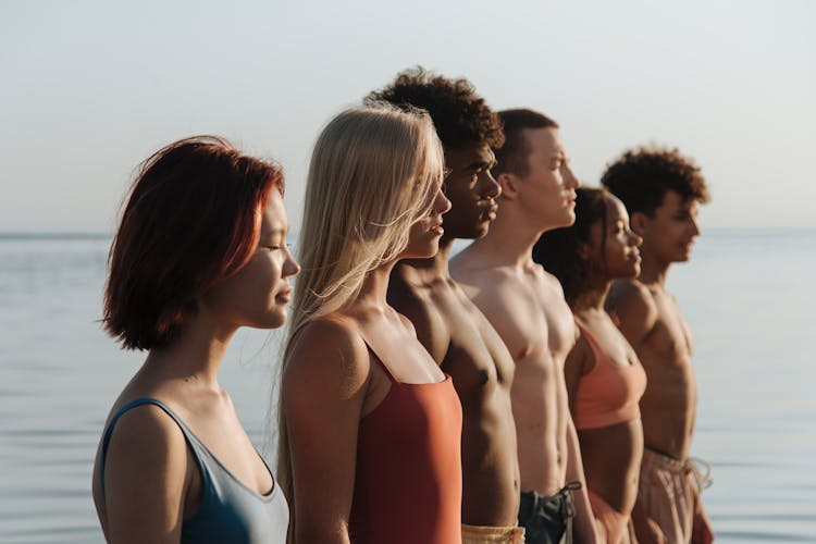 Teenagers Standing In Row At Seaside