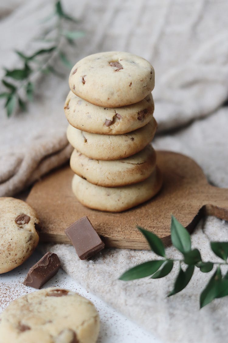 Stack Of Chocolate Chip Cookies On Wooden Cutting Board