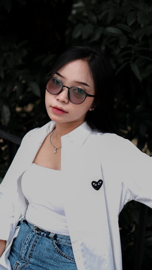 Free A Woman in Sunglasses Posing in a White Outfit Stock Photo