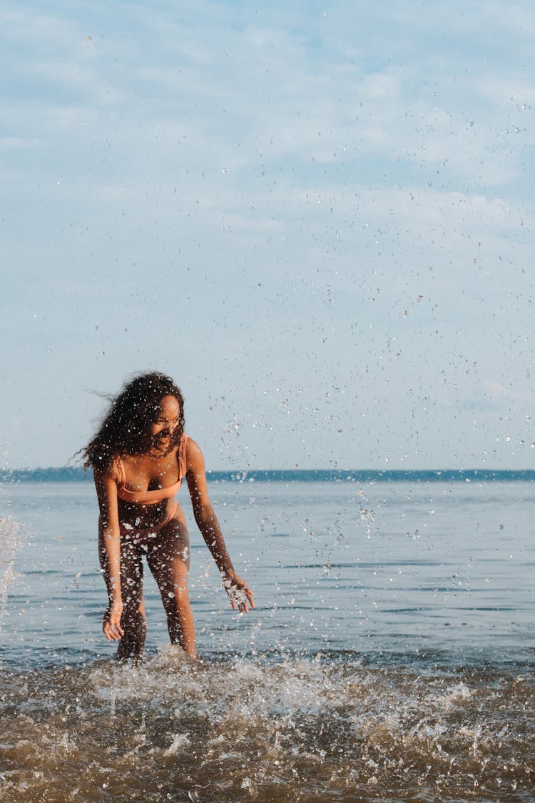 Teenage Girl Splashing Water In Sea