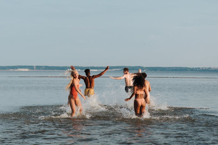 Friends Playing In Water In Summer