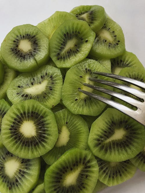 A Close-up Shot of Slices of Kiwi Fruits with a Fork