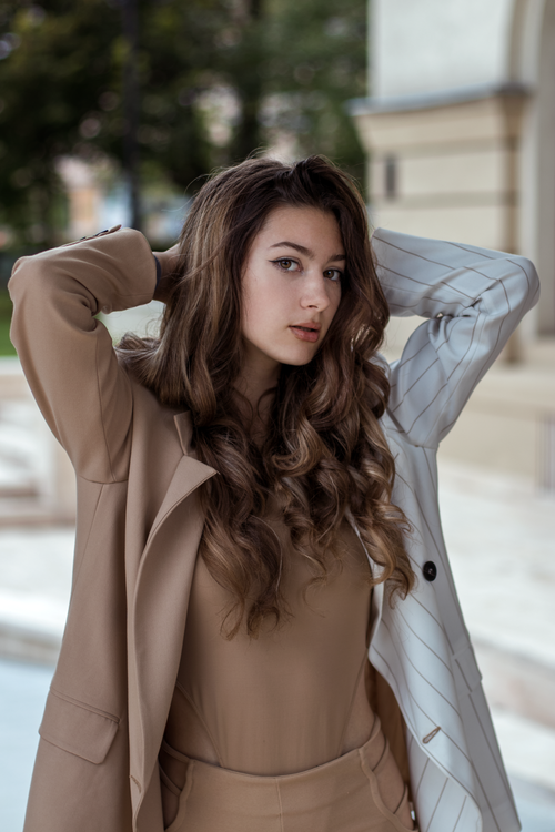 Free Confident young woman in smart casual outfit posing outdoors with stylish flair. Stock Photo
