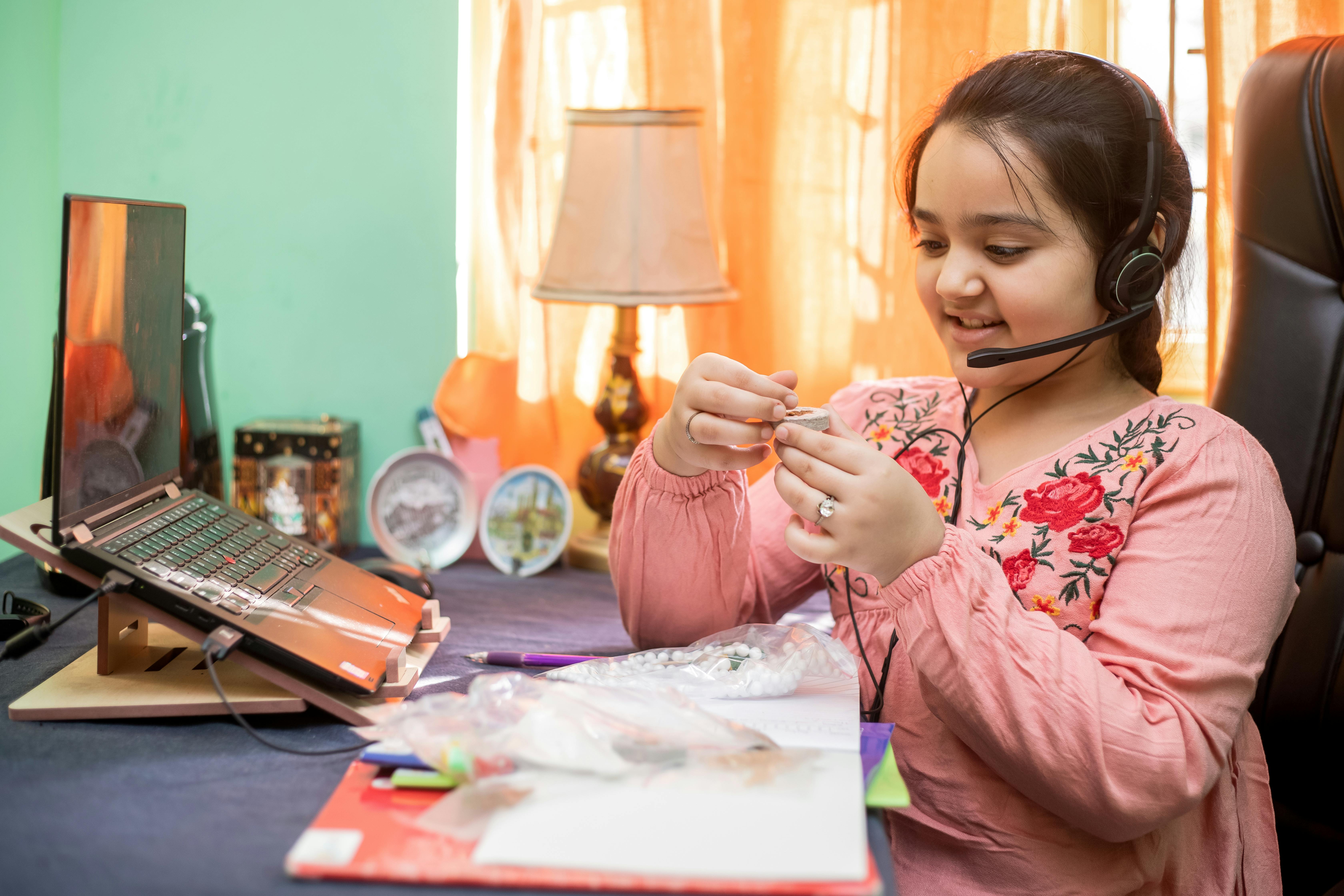 Free Girl in Pink and White Floral Long Sleeve Shirt Holding Pen Stock Photo