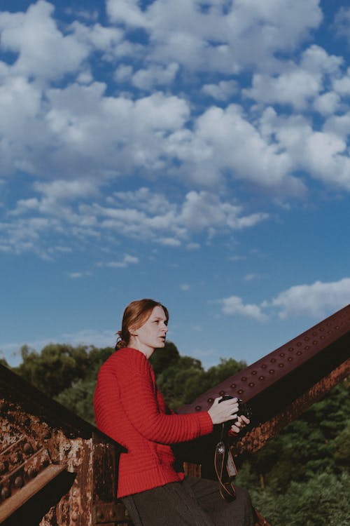 Free A Woman in a Red Sweater Holding a Camera Stock Photo