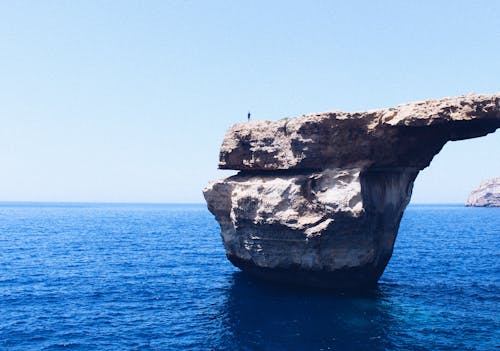 Free Person Standing on Rock Formation Cliff Stock Photo