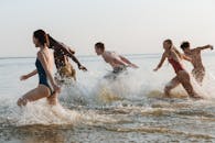 一群青少年在海浪中奔跑，享受夏日时光