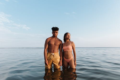 Free Man and Woman Standing on the Sea Water Stock Photo