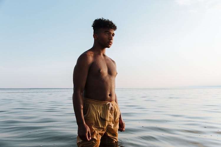 Portrait Of Shirtless Teenage Boy Standing In Water