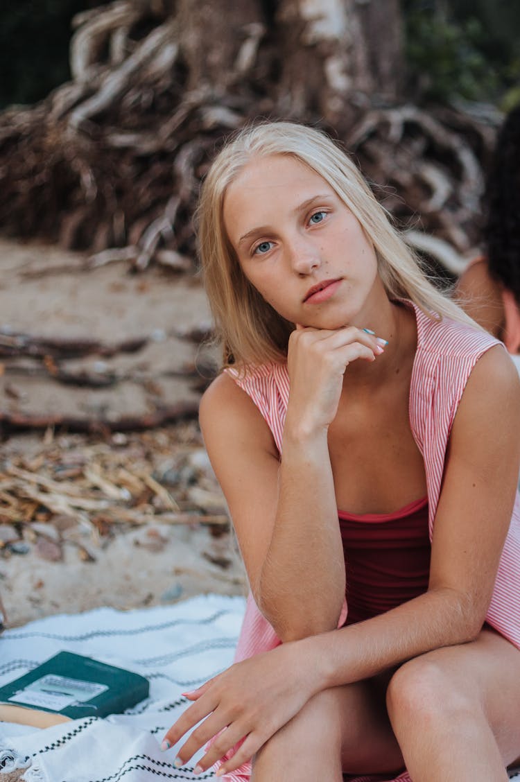 Girl Sitting On A Blanket On The Beach