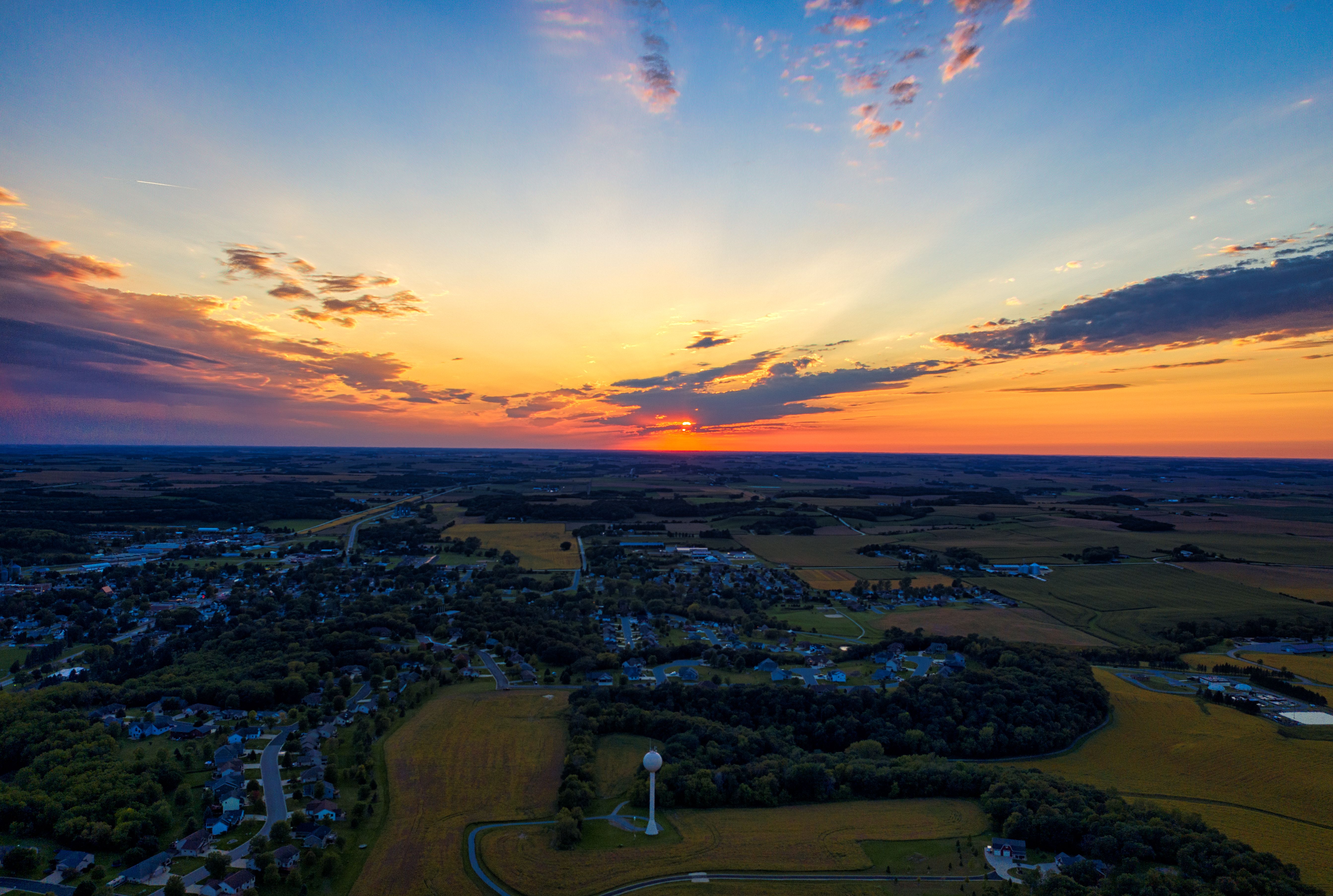 Breathtaking aerial view of Saint Charles, MN, showcasing a vibrant sunset over the countryside.