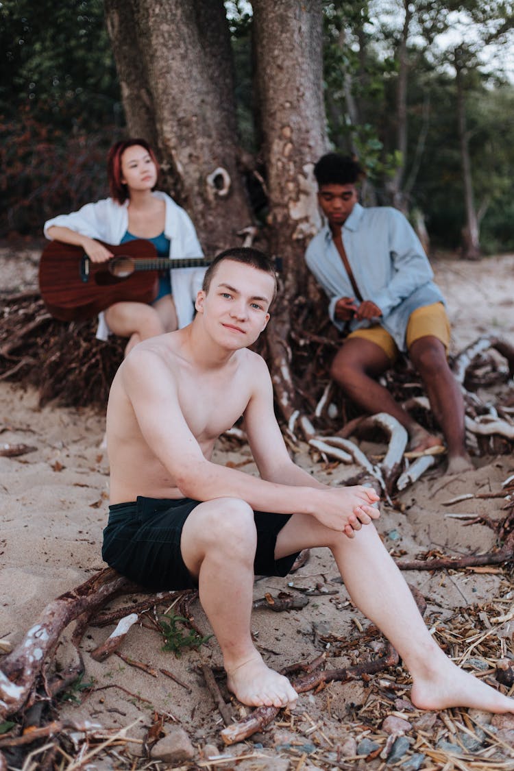 Friends Sitting On The Roots Of A Tree