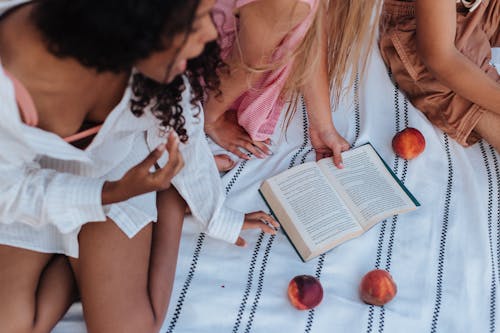 Free Girls on the Picnic Blanket Reading a Book Stock Photo