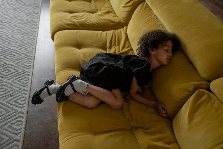 Cute Girl Sleeping On A Yellow Couch