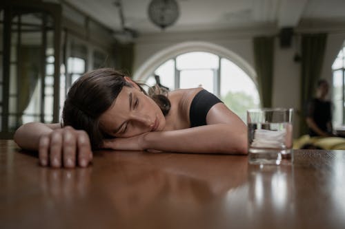 Free Woman Crying on a Wooden Table Stock Photo