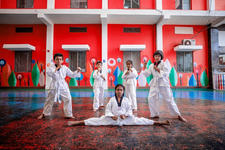 A Group Of Kids Wearing White Doboks Posing With Taekwondo Poses