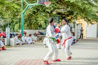 Man in White Karate Gi Holding White and Green Basketball