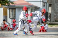 Men in White Karate Gi and Red Helmet Playing on Street