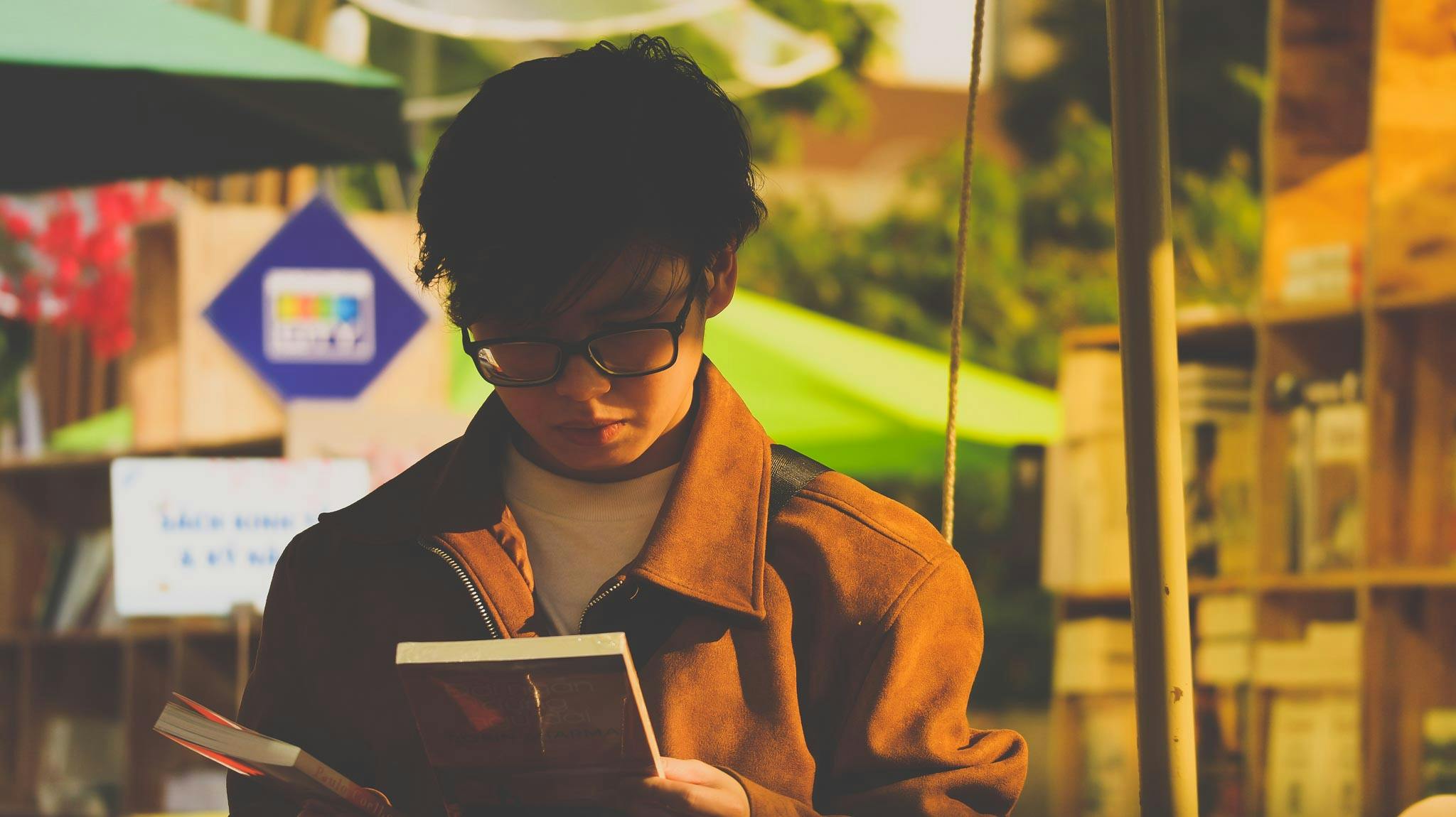 Man in Brown Jacket Holding a Book