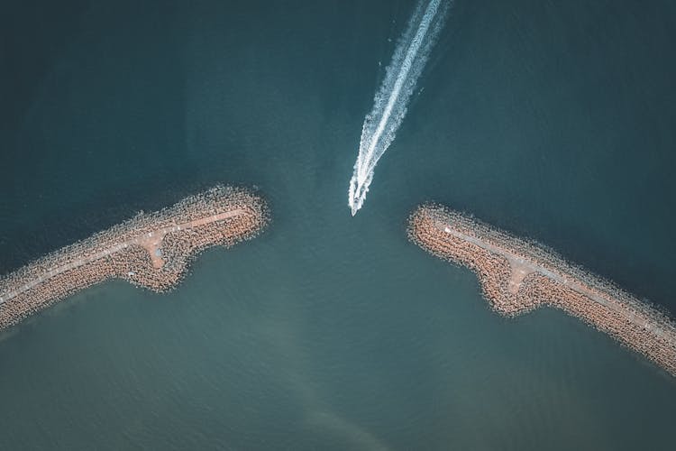 An Aerial Shot Of A Boat Going Through An Inlet