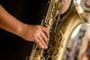 Free Person in Black Shirt Playing Brass-colored Saxophone Stock Photo