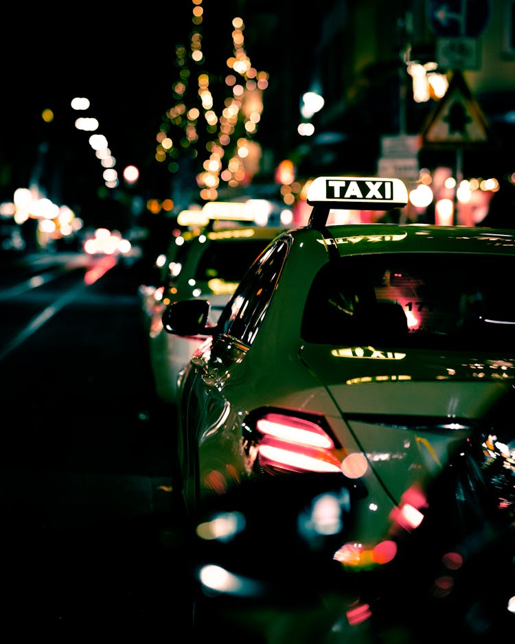 Green Taxi Lined Up Along A Road