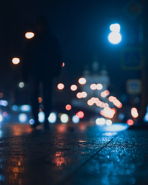 A Person Walking on the Street at Night