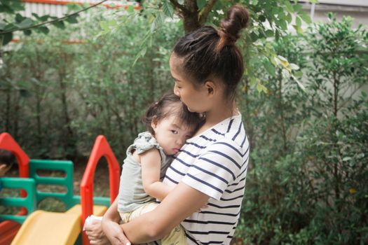 幼儿园老师蹲下身子安慰正在哭泣的幼儿