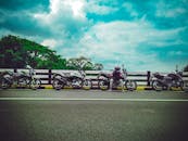 一名摩托车手在喀拉拉邦帕拉卡德一条风景优美的道路旁休息，周围停满了摩托车