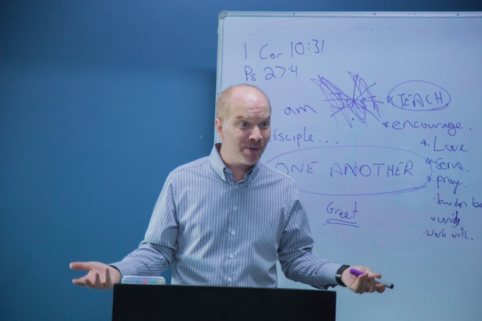 An instructor teaching an ASL class with students practicing handshapes respectfully