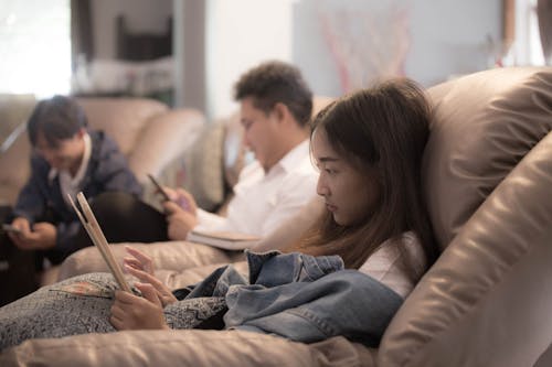 Free A Young Woman Using a Tablet on a Couch Stock Photo