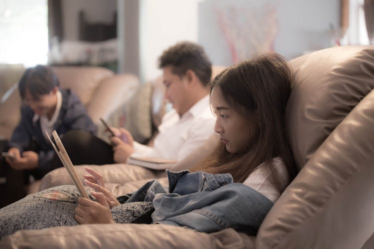 A Young Woman Using A Tablet On A Couch