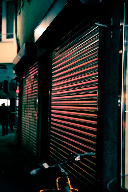 Volet roulant motorisé sur immeuble moderne Volet roulant fermé sur façade d'immeuble en soirée avec reflets lumineux