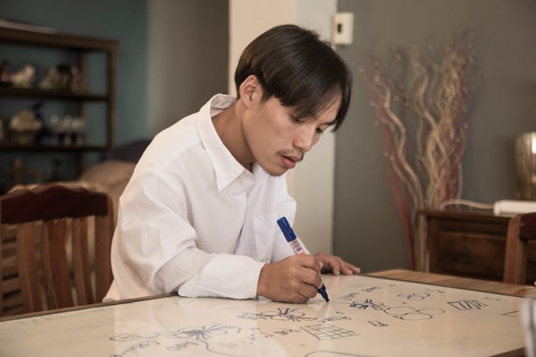 A Man Drawing On Whiteboard