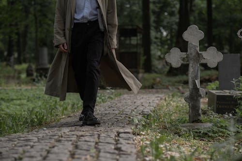 Man Walking in a Pathway in a Cemetery