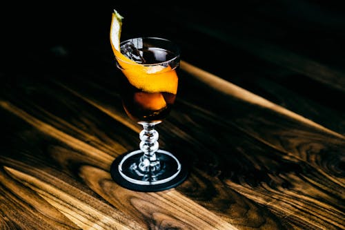 Бесплатное стоковое фото с бокал для коктейля, деревянная поверхность, коктейль