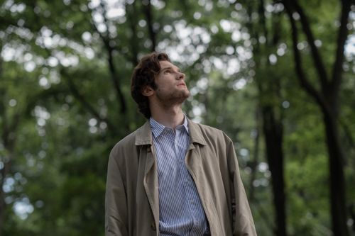 Free Adult man stands outdoors in forest, gazing upward. Tranquil natural setting. Stock Photo