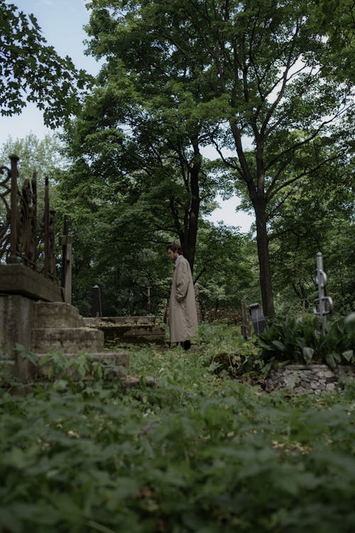 Free Man in Trench Coat Standing near a Grave Stock Photo