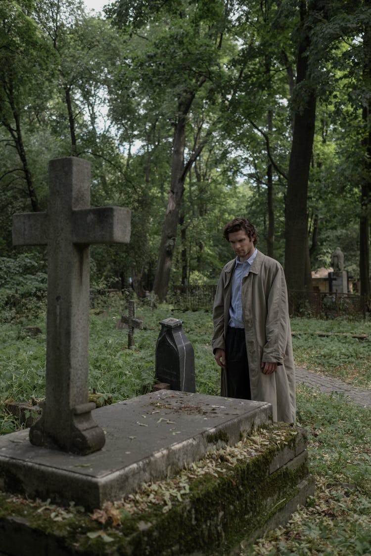 A Man Standing By A Grave