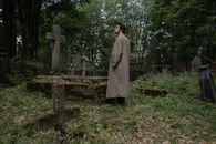 Woman in Brown Coat Standing Near Brown Wooden Fence
